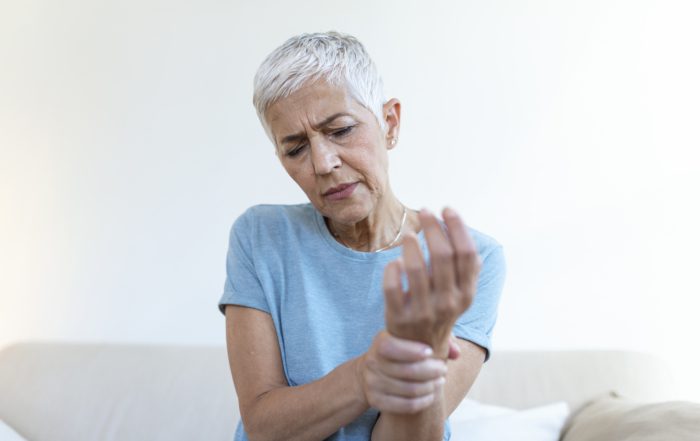 Elderly woman suffering from pain in hand, arthritis old person and senior woman female suffering from pain at home